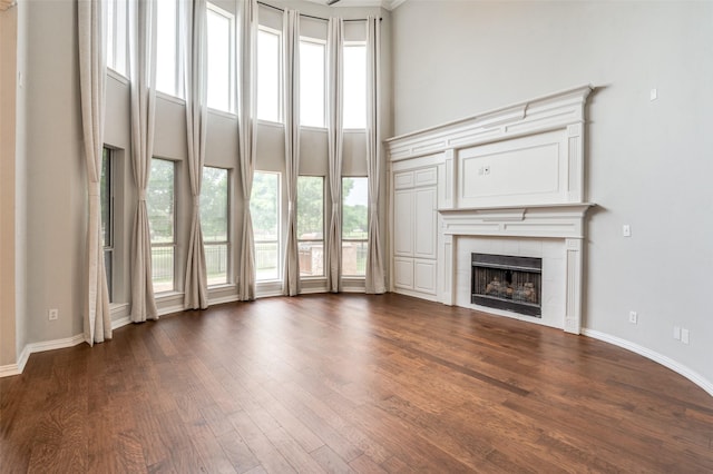4145 Victory Dr, Frisco, TX 75034 - unfurnished living room with a high ceiling, a fireplace, dark wood-style floors, and baseboards
