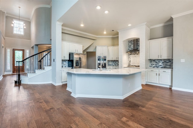 4145 Victory Dr, Frisco, TX 75034 - kitchen with wall chimney range hood, appliances with stainless steel finishes, white cabinetry, a kitchen island with sink, and dark wood finished floors