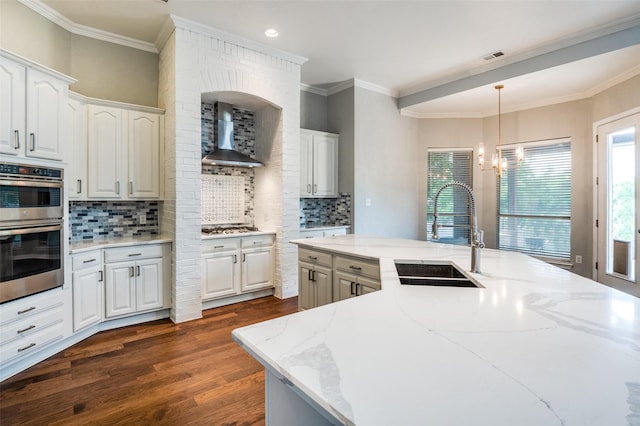 4145 Victory Dr, Frisco, TX 75034 - kitchen featuring appliances with stainless steel finishes, a sink, wall chimney exhaust hood, light stone countertops, and backsplash