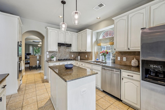 5603 Blazing Star Rd, Frisco, TX 75036 - kitchen with appliances with stainless steel finishes, a sink, arched walkways, under cabinet range hood, and light tile patterned floors