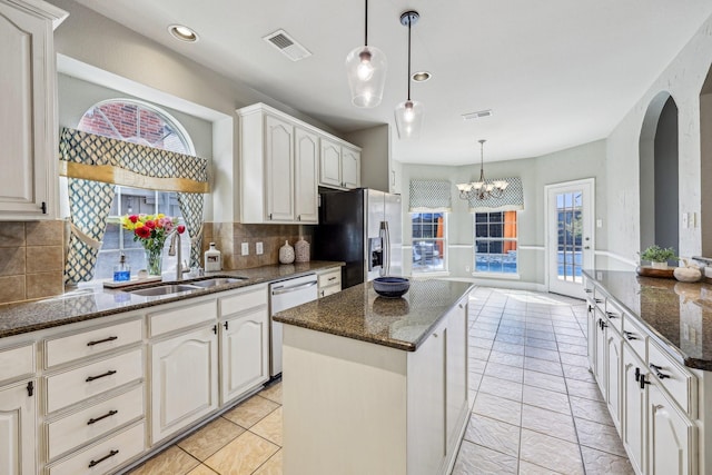 5603 Blazing Star Rd, Frisco, TX 75036 - kitchen with a sink, stainless steel fridge, dishwashing machine, decorative backsplash, and arched walkways