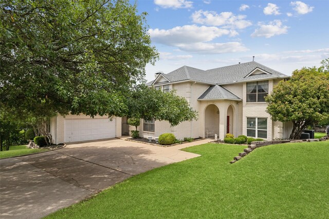7632 Westwind Dr, Fort Worth, TX 76179 - view of front of house featuring brick siding, driveway, a front yard, roof with shingles, and an attached garage