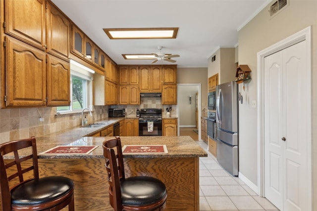7632 Westwind Dr, Fort Worth, TX 76179 - kitchen with black appliances, a sink, a peninsula, brown cabinets, and crown molding