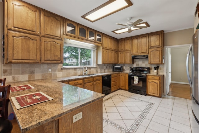 7632 Westwind Dr, Fort Worth, TX 76179 - kitchen with black appliances, a sink, a peninsula, brown cabinets, and under cabinet range hood