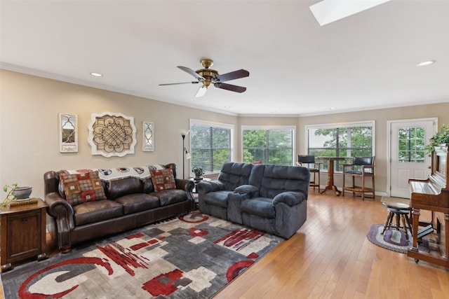 7632 Westwind Dr, Fort Worth, TX 76179 - living area with plenty of natural light, a ceiling fan, light wood-style floors, a skylight, and ornamental molding