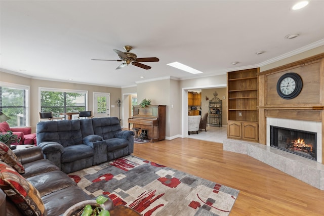 7632 Westwind Dr, Fort Worth, TX 76179 - living room featuring a high end fireplace, light wood-type flooring, crown molding, a ceiling fan, and recessed lighting
