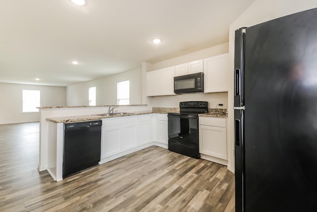 330 Flagship Ln, Gun Barrel City, TX 75156 - kitchen with black appliances, a sink, plenty of natural light, light stone countertops, and recessed lighting