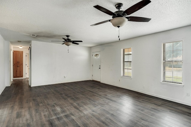 5140 Kingston Dr, Wichita Falls, TX 76310 - unfurnished living room featuring a ceiling fan, a textured ceiling, plenty of natural light, dark wood finished floors, and baseboards