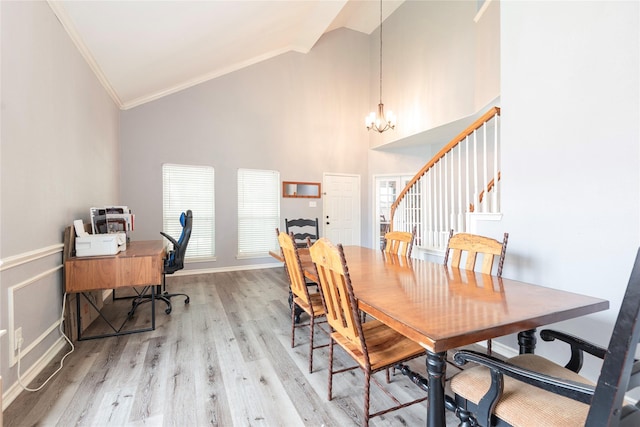 dining space with ornamental molding, a chandelier, light wood finished floors, stairway, and high vaulted ceiling