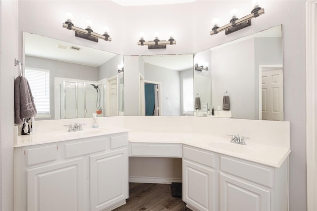 full bathroom with a shower stall, wood finished floors, and vanity