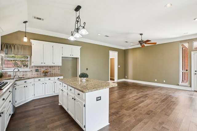 612 Christan Ct, Rockwall, TX 75087 - kitchen featuring a sink, ceiling fan, a center island, decorative backsplash, and white cabinets