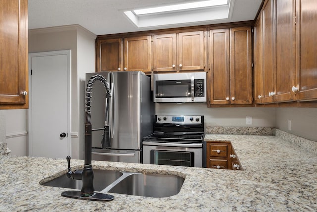 178 Norwood Dr, Woodway, TX 76712 - kitchen with stainless steel appliances, light stone countertops, and brown cabinets