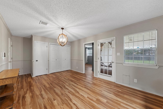 178 Norwood Dr, Woodway, TX 76712 - unfurnished dining area featuring light wood finished floors, a textured ceiling, a chandelier, ornamental molding, and baseboards