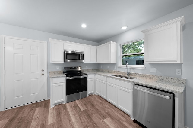 804 Hemlock Dr, West Tawakoni, TX 75474 - kitchen with stainless steel appliances, a sink, wood finished floors, white cabinetry, and recessed lighting