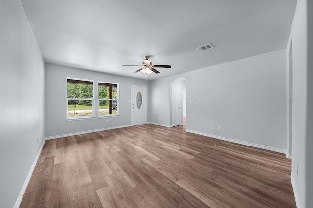 804 Hemlock Dr, West Tawakoni, TX 75474 - empty room featuring arched walkways, wood finished floors, a ceiling fan, and baseboards