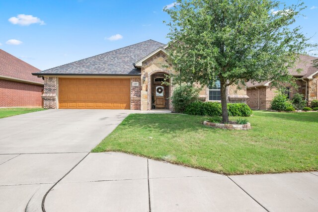 4307 Savannah Ln, Granbury, TX 76049 - view of front of house featuring brick siding, a garage, a front yard, and concrete driveway