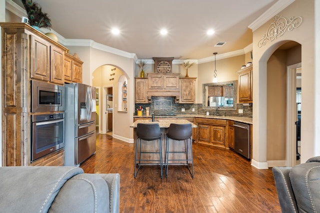 4307 Savannah Ln, Granbury, TX 76049 - kitchen featuring appliances with stainless steel finishes, arched walkways, light stone counters, open floor plan, and tasteful backsplash