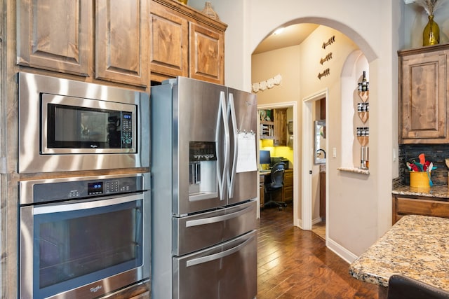4307 Savannah Ln, Granbury, TX 76049 - kitchen with stainless steel appliances, dark wood-style floors, light stone counters, baseboards, and tasteful backsplash