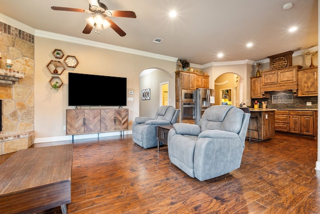 4307 Savannah Ln, Granbury, TX 76049 - living area with arched walkways, crown molding, ceiling fan, recessed lighting, and dark wood-type flooring