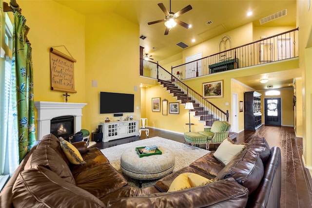 3030 Maverick Dr, Forney, TX 75126 - living room with ceiling fan, wood finished floors, a high ceiling, baseboards, and a glass covered fireplace