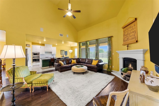 3030 Maverick Dr, Forney, TX 75126 - living area with wood-type flooring, a ceiling fan, high vaulted ceiling, and a warm lit fireplace