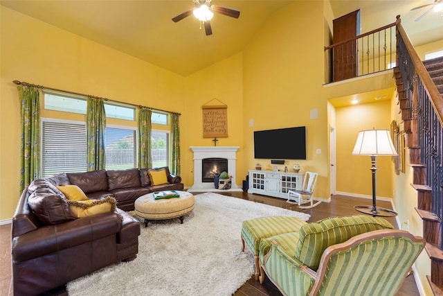 3030 Maverick Dr, Forney, TX 75126 - living room with ceiling fan, stairs, high vaulted ceiling, a warm lit fireplace, and baseboards