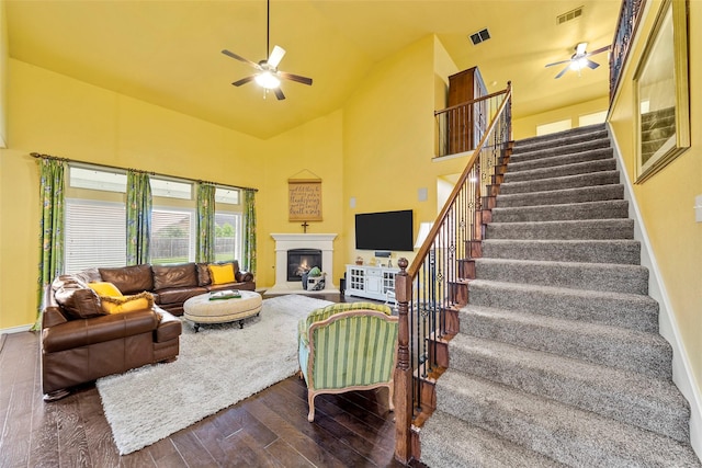 3030 Maverick Dr, Forney, TX 75126 - living room featuring ceiling fan, stairs, dark wood-style flooring, a glass covered fireplace, and high vaulted ceiling