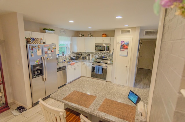 2209 Ridgewood Dr, Sherman, TX 75092 - kitchen featuring stainless steel appliances, a sink, white cabinets, light countertops, and recessed lighting
