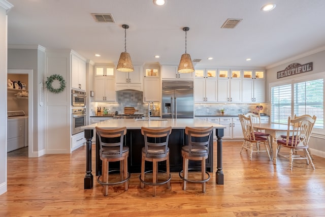 112 Mustang Dr, Fate, TX 75087 - kitchen with stainless steel appliances, a sink, crown molding, washer / clothes dryer, and backsplash