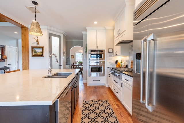 112 Mustang Dr, Fate, TX 75087 - kitchen featuring appliances with stainless steel finishes, a sink, white cabinetry, pendant lighting, and light stone counters