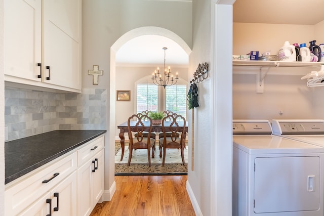 112 Mustang Dr, Fate, TX 75087 - washroom with washing machine and dryer, light wood finished floors, ornamental molding, arched walkways, and cabinet space