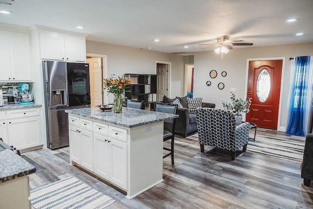 1313 E Turley St, Sherman, TX 75090 - kitchen featuring stainless steel fridge with ice dispenser, ceiling fan, a breakfast bar area, light wood-type flooring, and recessed lighting