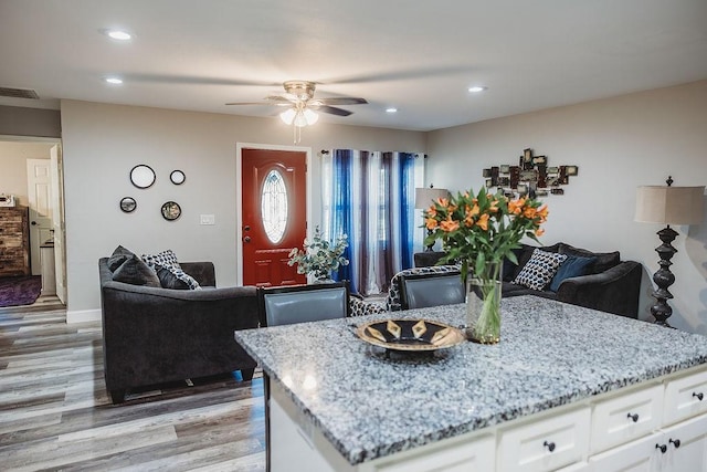 1313 E Turley St, Sherman, TX 75090 - kitchen with light wood-type flooring, open floor plan, a ceiling fan, light stone countertops, and white cabinets