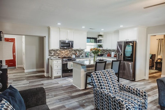 1313 E Turley St, Sherman, TX 75090 - kitchen featuring stainless steel appliances, wood finished floors, white cabinets, backsplash, and recessed lighting