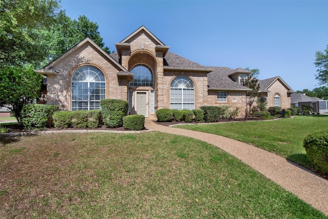 2103 Greenbrier St, Denison, TX 75020 - view of front of home with brick siding, a shingled roof, and a front yard