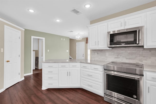 2103 Greenbrier St, Denison, TX 75020 - kitchen with stainless steel appliances, a peninsula, dark wood-style floors, decorative backsplash, and recessed lighting