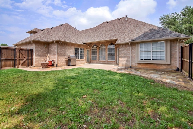 2103 Greenbrier St, Denison, TX 75020 - back of property featuring roof with shingles, brick siding, a patio, and a gate