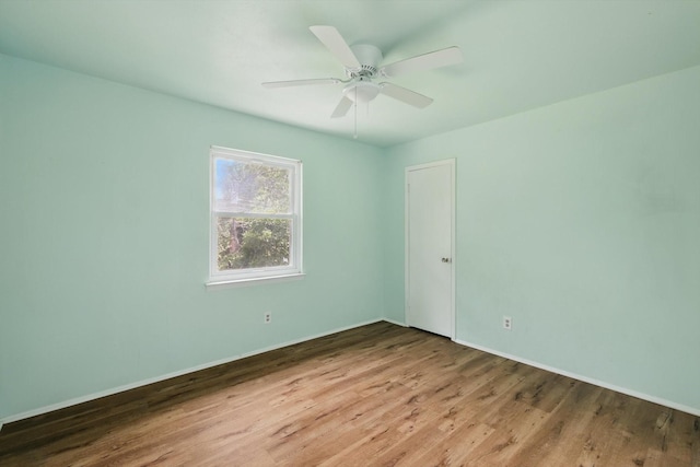 spare room with wood finished floors, baseboards, and ceiling fan