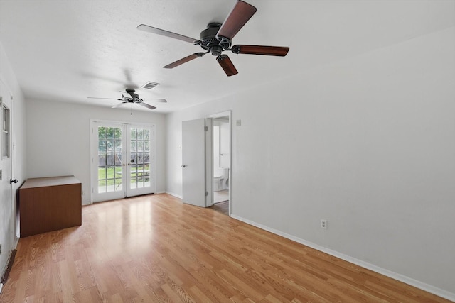 spare room featuring a ceiling fan, light wood-type flooring, and baseboards