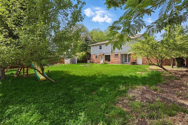 view of yard featuring a storage unit, french doors, and an outdoor structure