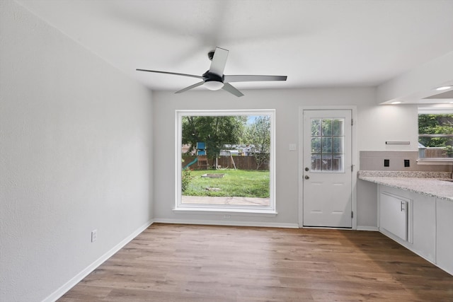 entryway with wood finished floors, ceiling fan, and baseboards