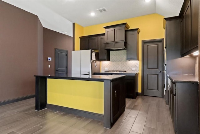 3005 Knoxbridge Rd, Forney, TX 75126 - kitchen with freestanding refrigerator, a center island with sink, tasteful backsplash, wood finished floors, and recessed lighting