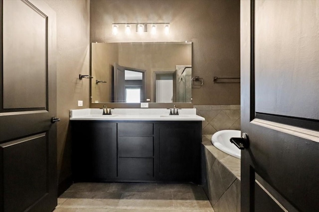 3005 Knoxbridge Rd, Forney, TX 75126 - bathroom featuring double vanity, tiled tub, and tile patterned flooring
