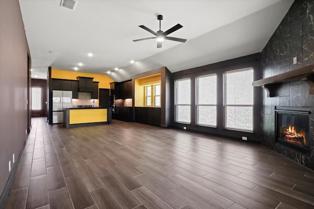 3005 Knoxbridge Rd, Forney, TX 75126 - unfurnished living room featuring lofted ceiling, dark wood-type flooring, a ceiling fan, and a fireplace