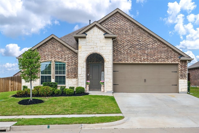 303 Headwater Dr, Fate, TX 75087 - french provincial home featuring stone siding, driveway, a garage, and brick siding