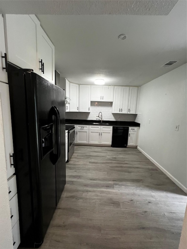3024 Carnation Ave, Fort Worth, TX 76111 - kitchen featuring black appliances, dark countertops, white cabinetry, baseboards, and a textured ceiling