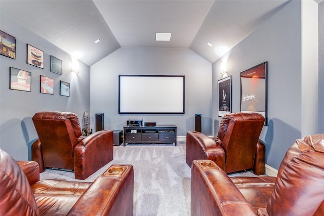 carpeted cinema featuring lofted ceiling and baseboards