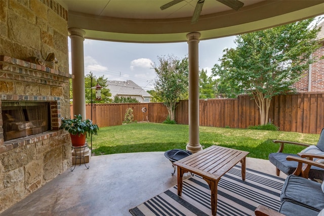 view of patio with an outdoor stone fireplace and ceiling fan