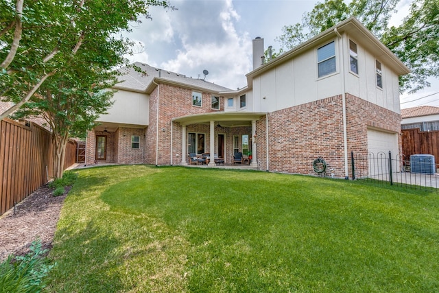 rear view of property with central AC unit, an attached garage, brick siding, a chimney, and a patio
