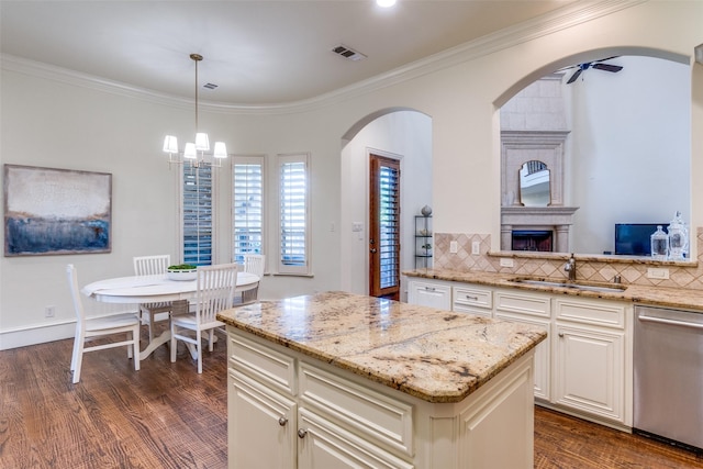 kitchen featuring dishwasher, a sink, light stone counters, dark wood-style flooring, and crown molding